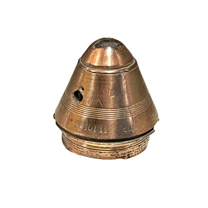 WW1 brass fuse paperweight with markings from use on a white background