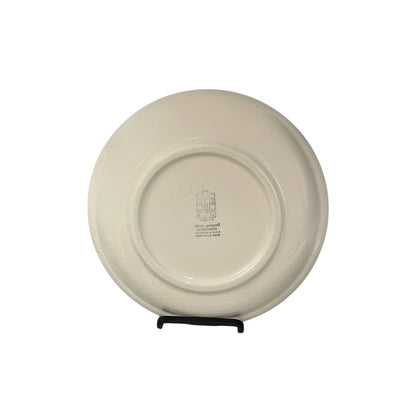 Beige ceramic plate on a stand with a visible brand logo on a white background