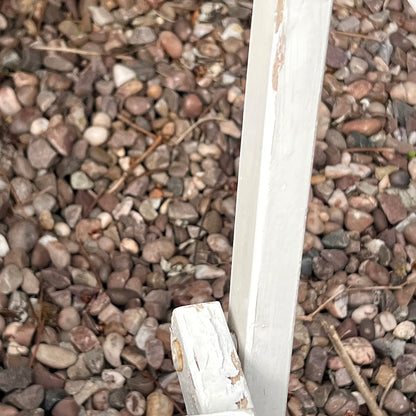 Close-up detail of French wooden slatted chairs, highlighting their condition in an outdoor setting.