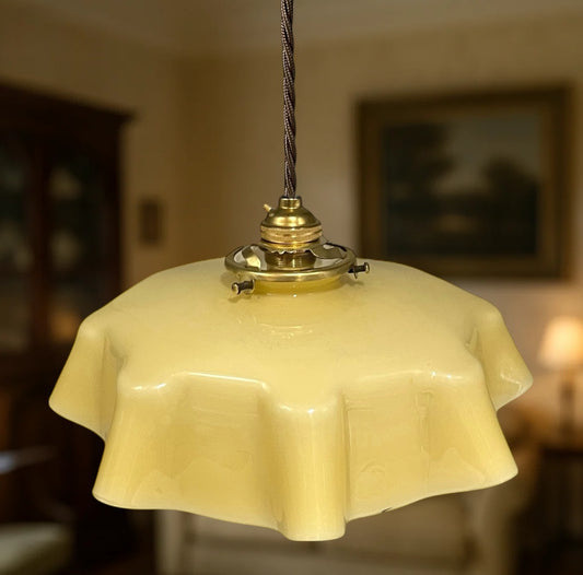 Vintage-style pendant light with a yellow glass shade in a softly blurred room setting