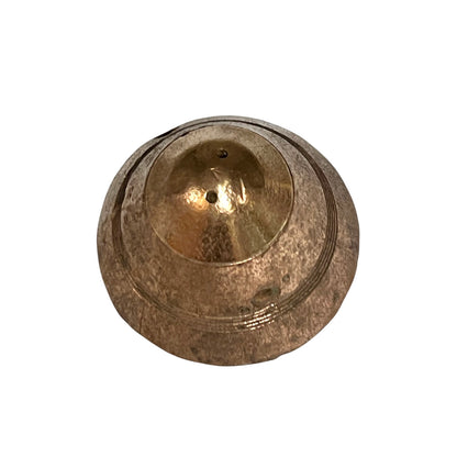 A small WW1 brass fuse paperweight with a textured finish on a white background - top view 