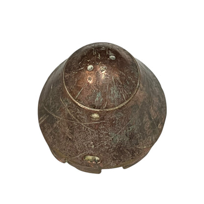 WW1 British brass fuse now repurposed as a paperweight on a white background