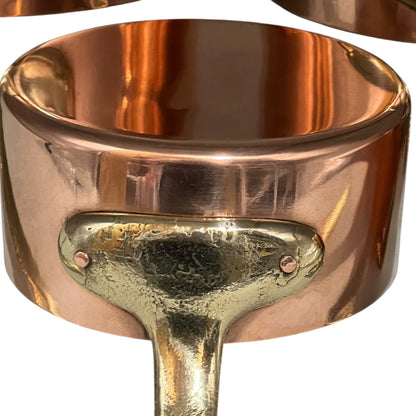 Close-up of a copper pot with a brass handle on a white background