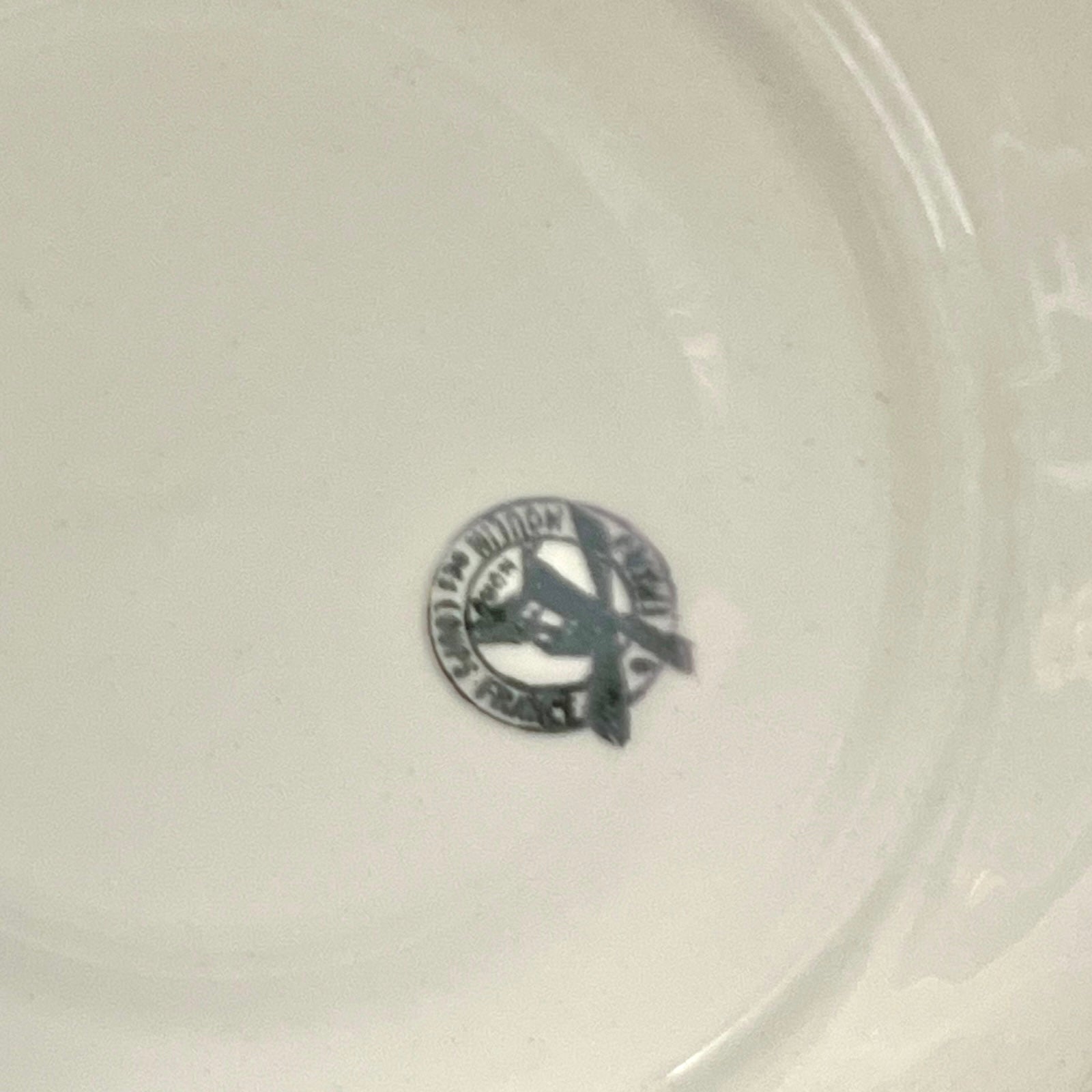 Close-up of a white ceramic plate with a logo in the center.