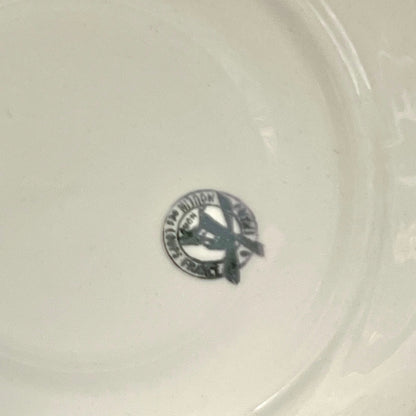 Close-up of a white ceramic plate with a logo in the center.