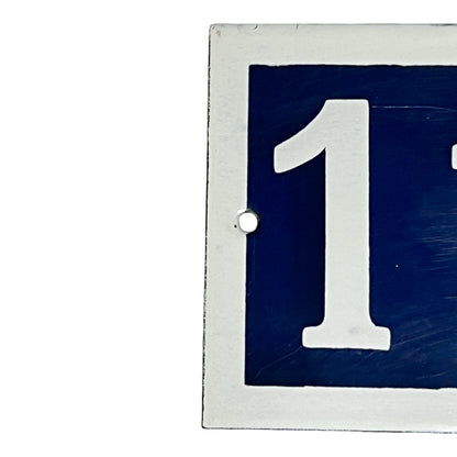 Close up of French enamel door number on a white background