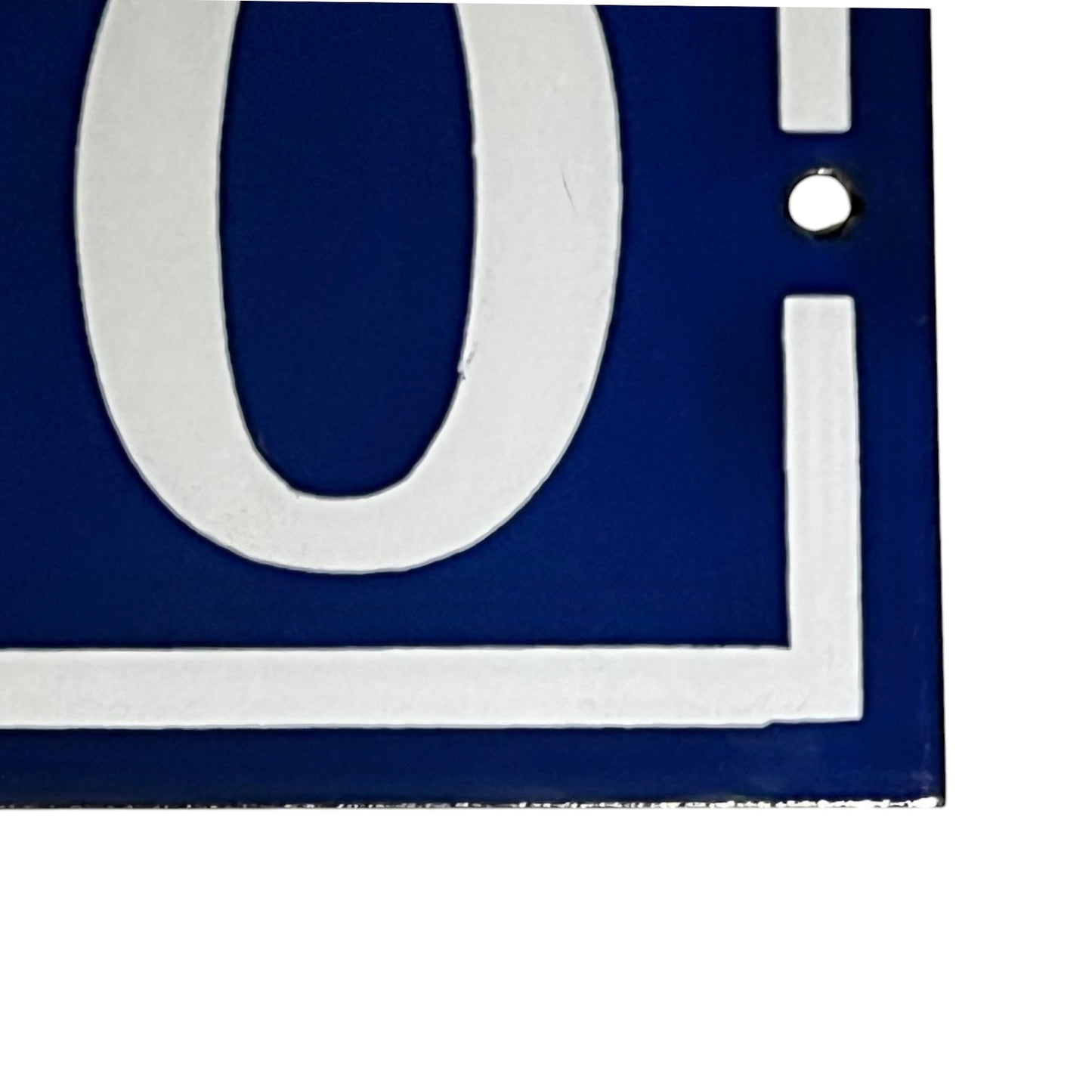 Close-up of a blue and white door number on a white background