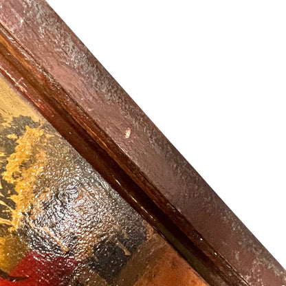 Close-up detail of a framed artwork corner, showing a dark reddish-brown wooden frame bordering a textured painting with gold, red, and dark tones against a white background.