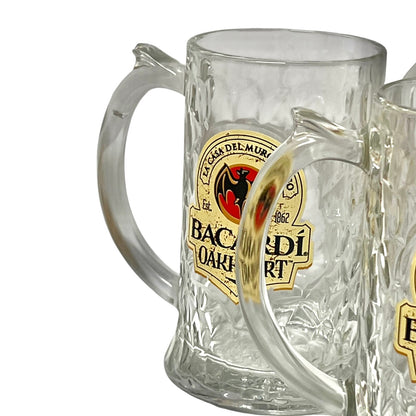 A clear textured glass beer mug with a curved handle and a gold, black, and red Baderlart logo, shown on a white background.