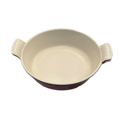An oval ceramic baking dish with two side handles, featuring a glossy off-white interior and a dark reddish-brown exterior, shown against a plain white background.