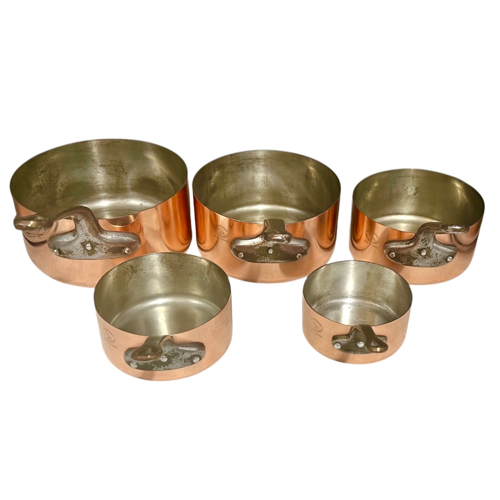 Close-up of copper cookware with iron handles on a white background