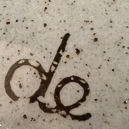 Close up of a speckled ceramic container on a white background