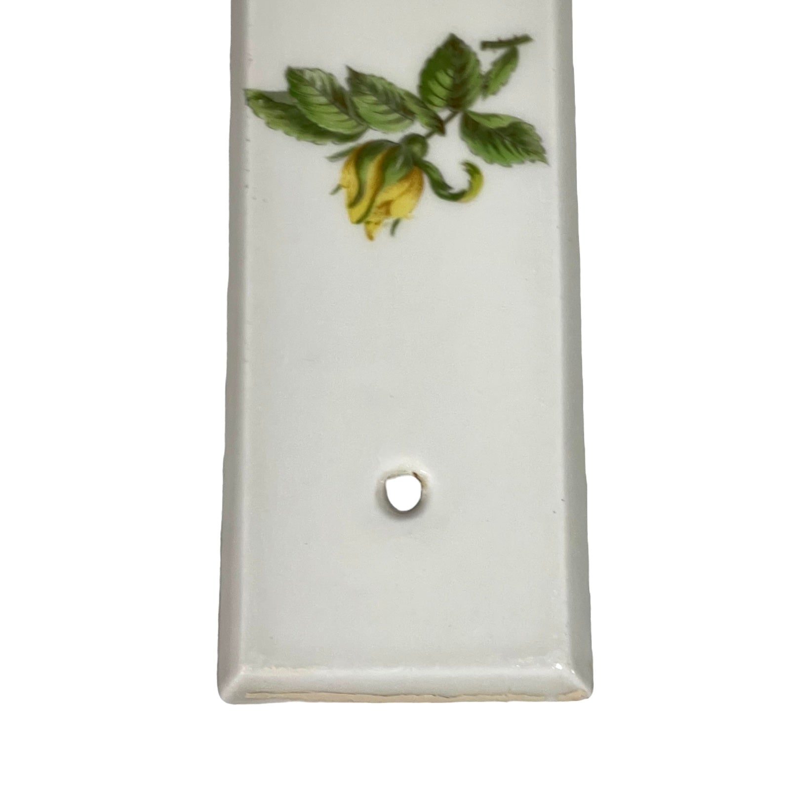 close up of door push plate with a yellow rose decoration on a white background