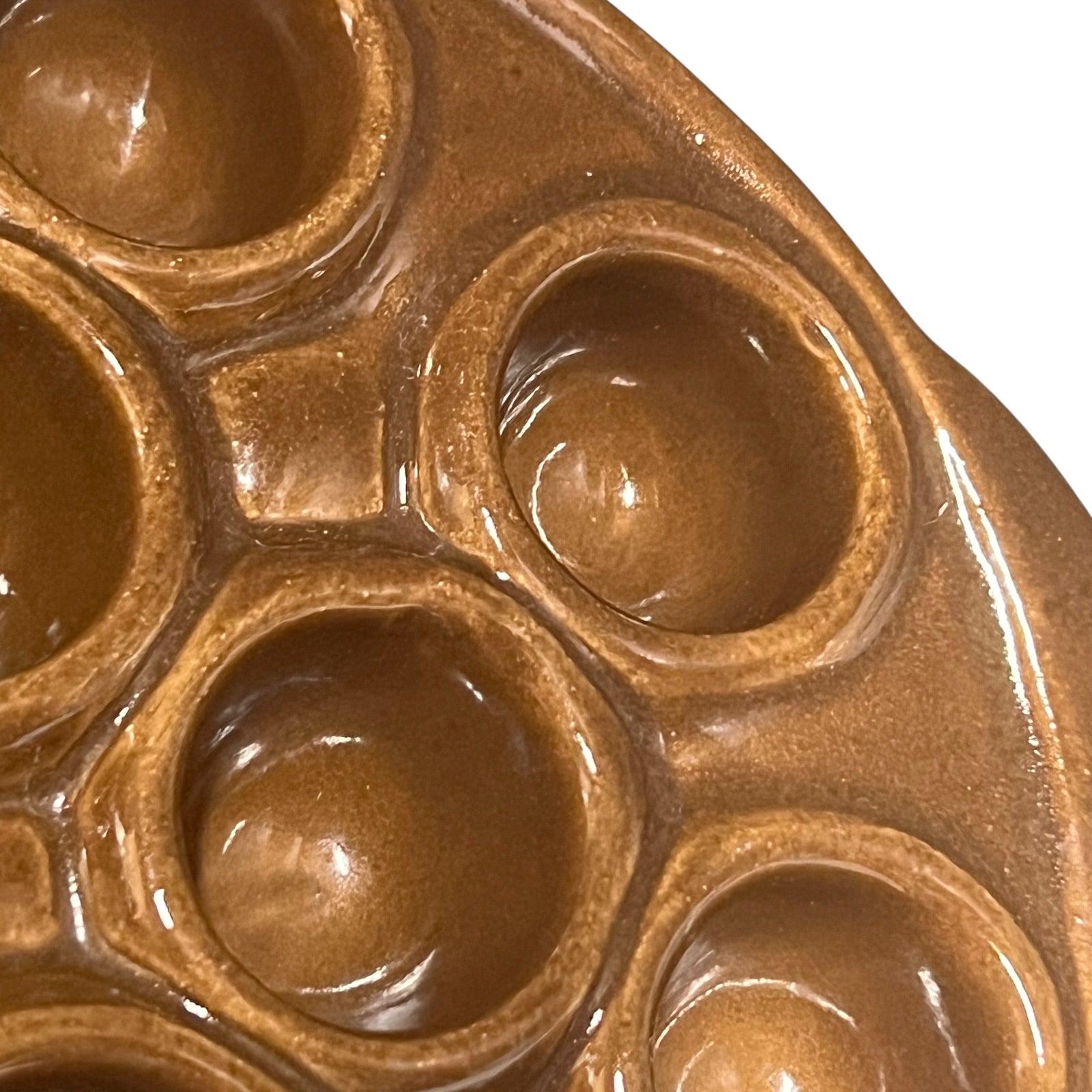 Close-up of a French escargot serving plate against a white background.