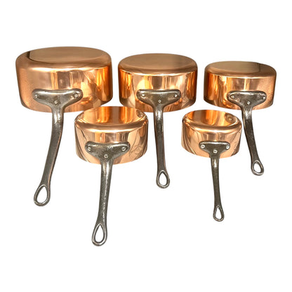 Set of 5 copper saucepans with iron handles on a white background