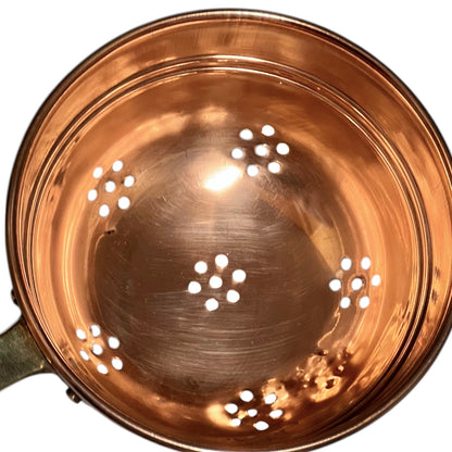 Small copper French sieve with a brass handle on a white background