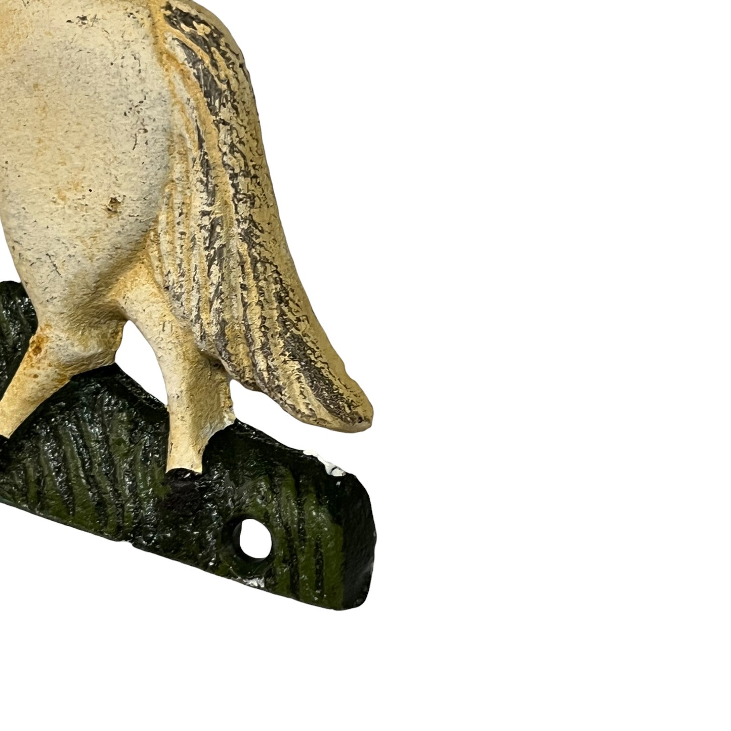 Close-up of a decorative horse figurine showing the rear body, tail, and one leg standing on a dark green textured base with a round hole, photographed against a plain white background.