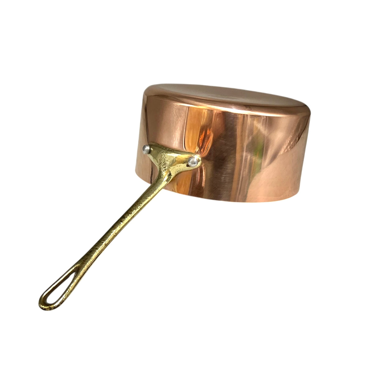 A copper saucepan with a shiny metallic finish and a long, textured brass-colored handle, shown on a plain white background.