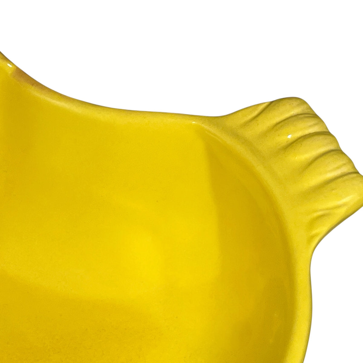 Close-up of a bright yellow ceramic bowl with a ribbed handle, shown against a plain white background.