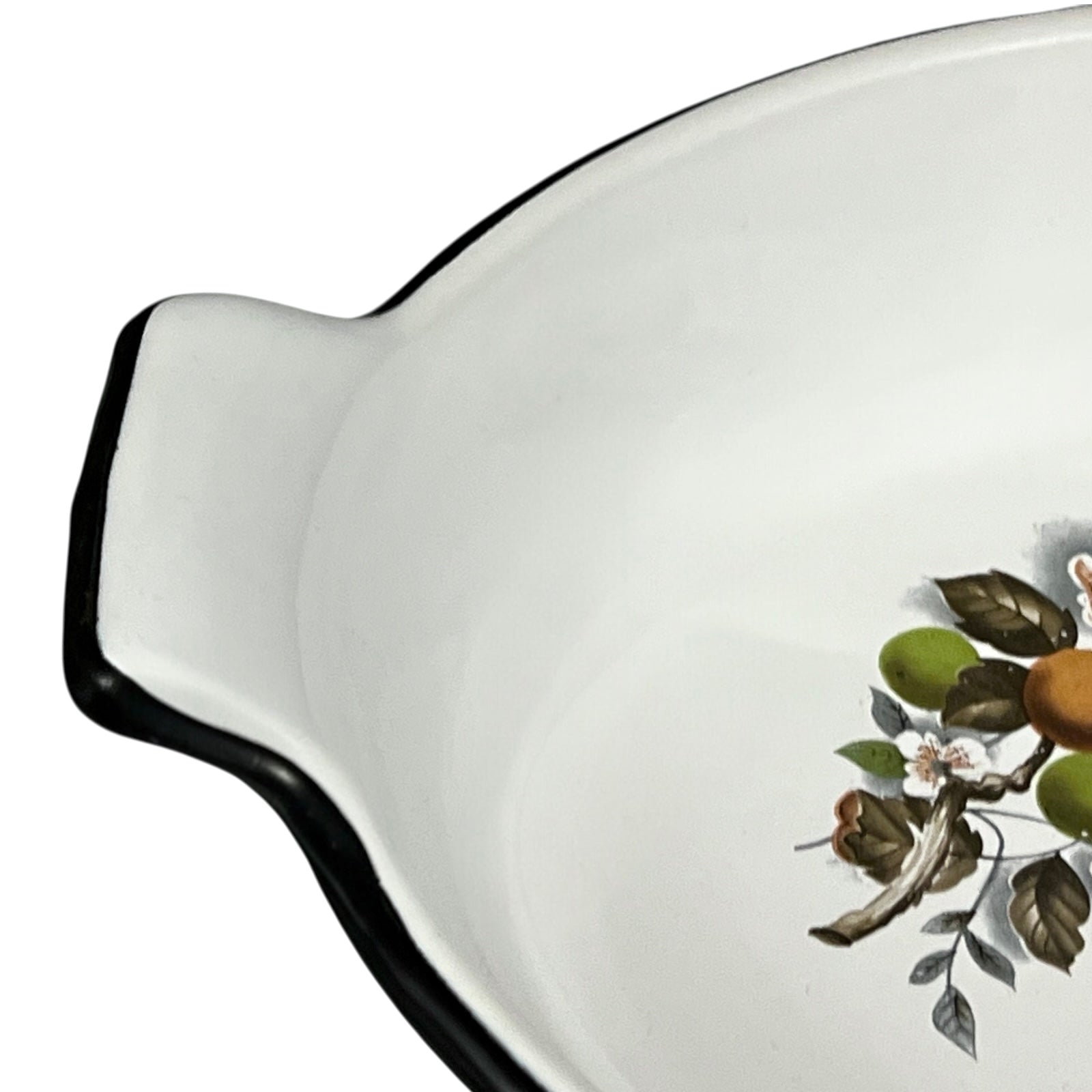White enamel dish with black rim and floral design on a white background