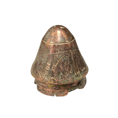 WW1 British brass fuse now repurposed as a paperweight on a white background