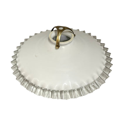 White glass lamp shade with a brass fitting on a white background