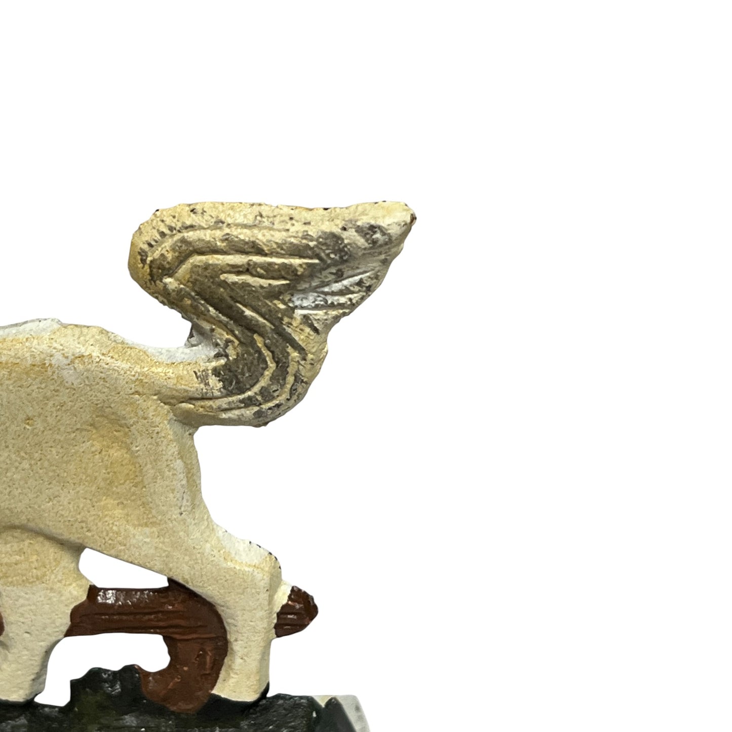Close-up of a small horse figurine or sculpture on a white background, showing part of its body and wing with a textured off-white surface and a dark brown base.