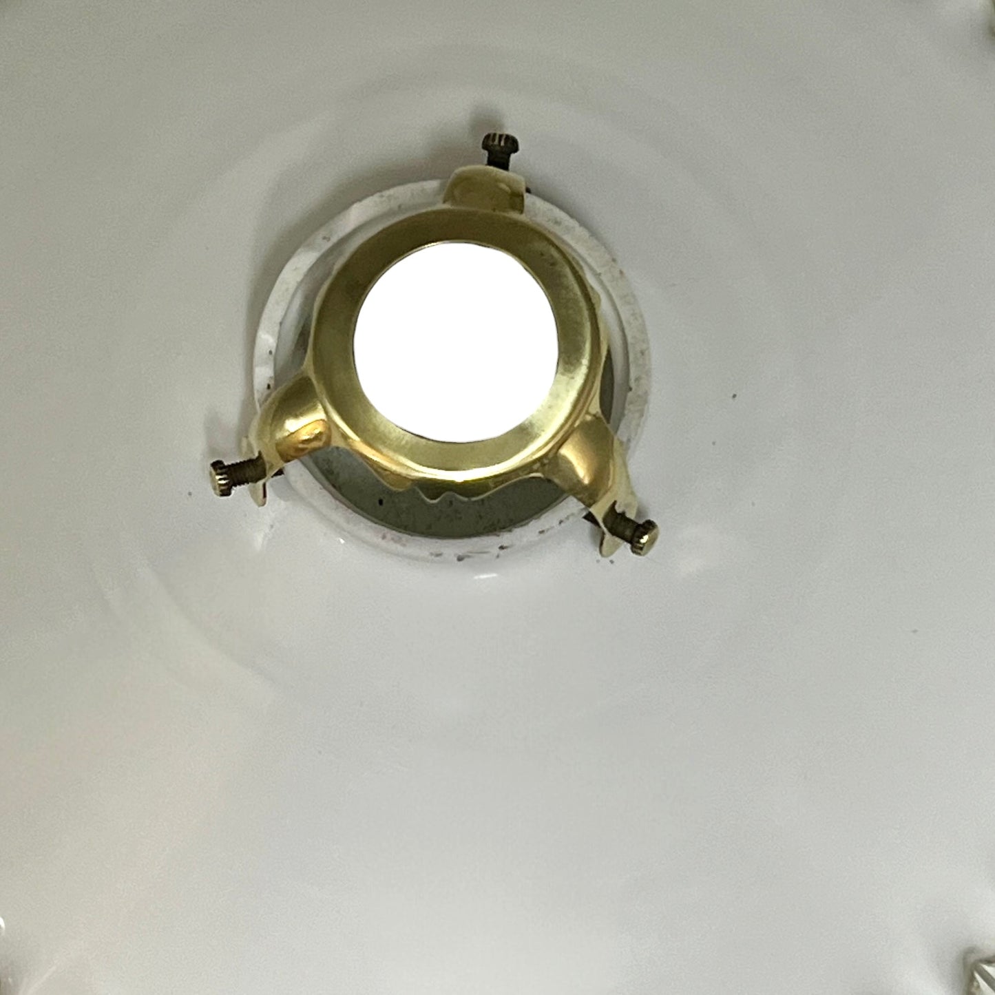 Close-up of a milk-glass frilled-edge lampshade against a white background.