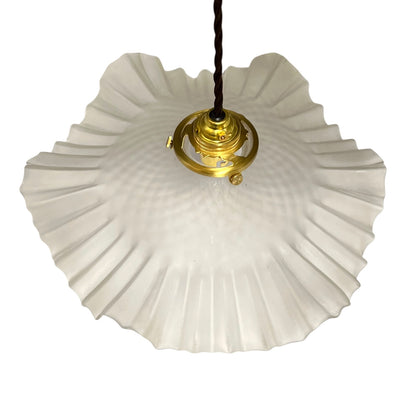 A vintage-style pendant light with a large, scalloped white glass shade and a polished gold brass fixture, suspended by a black cord against a plain white background.