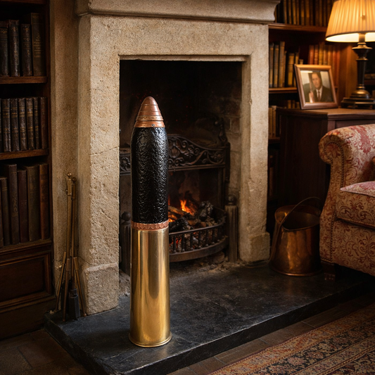 WW1 18 pounder door stop or fireside ornament in front of a fireplace with bookshelves and a chair in the background.