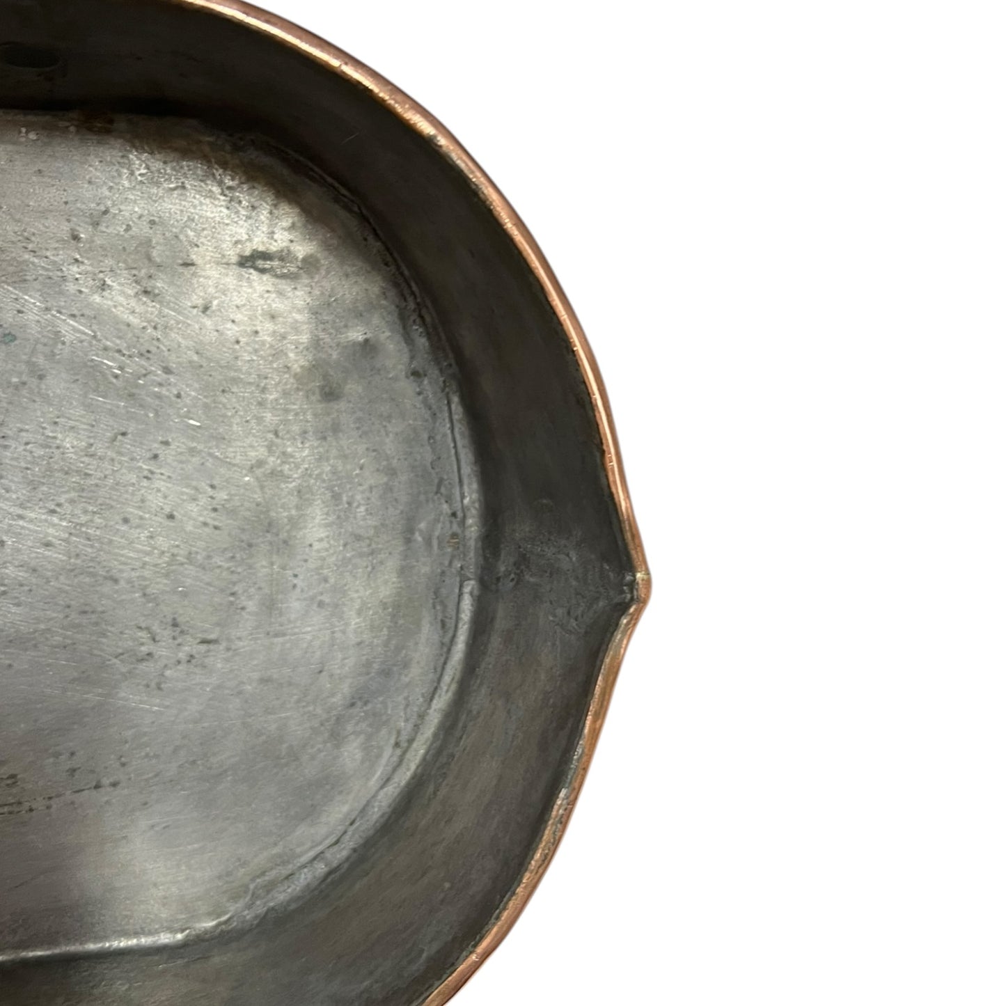 Close up of a copper roasting pan with a long handle on a white background