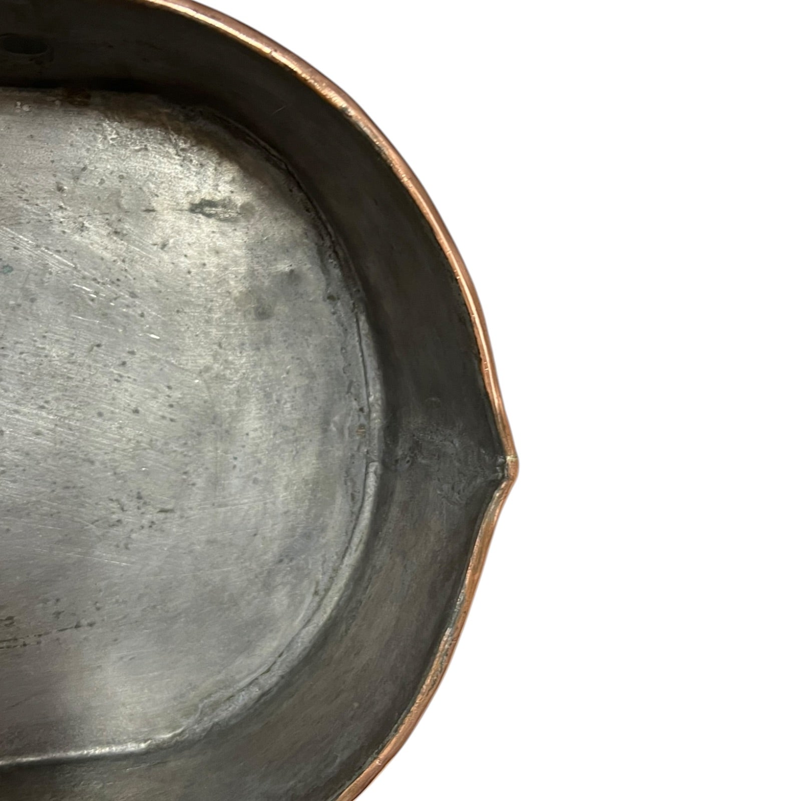 Close up of a copper roasting pan with a long handle on a white background