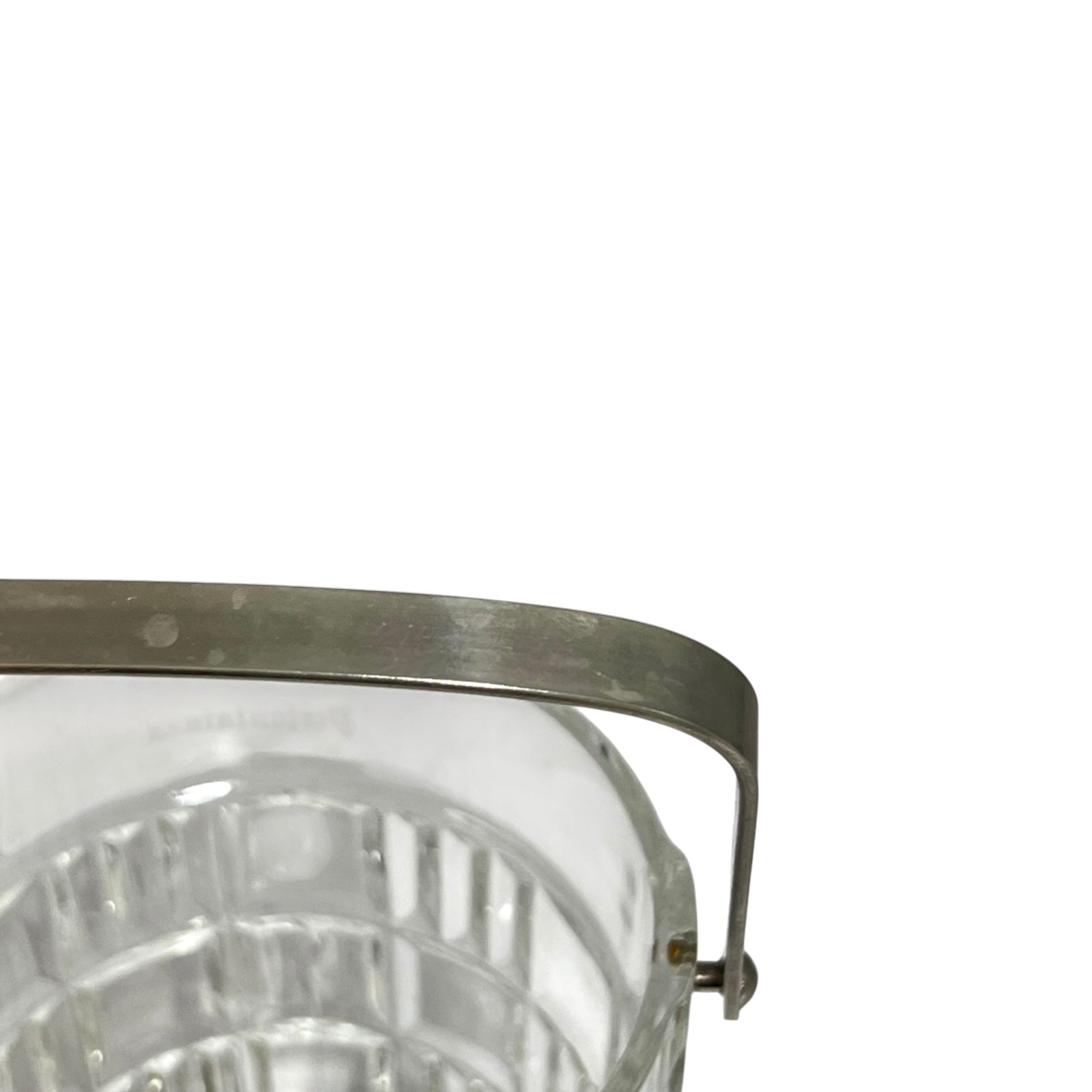 Close-up of a clear glass container or bucket with a curved metal handle and rim, shown against a plain white background.