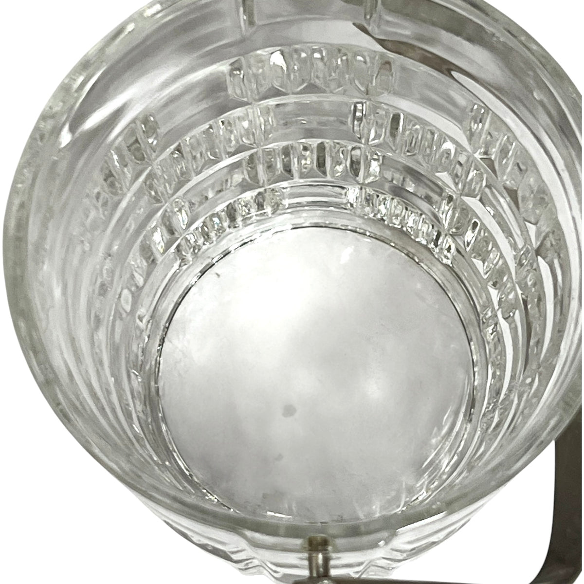 Clear glass ice bucket viewed from above, showing a textured, ribbed pattern on the sides and a white plastic insert at the bottom.