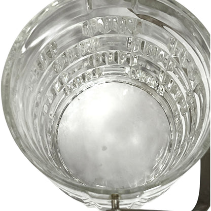 Clear glass ice bucket viewed from above, showing a textured, ribbed pattern on the sides and a white plastic insert at the bottom.