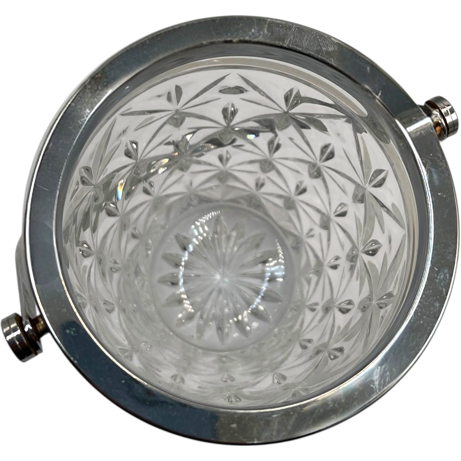 Close up of French cut glass ice bucket with textured design and metal handle on a white background 