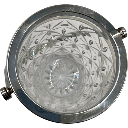 Close up of French cut glass ice bucket with textured design and metal handle on a white background 
