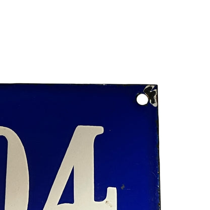 Close-up of a blue sign with white lettering on a white background
