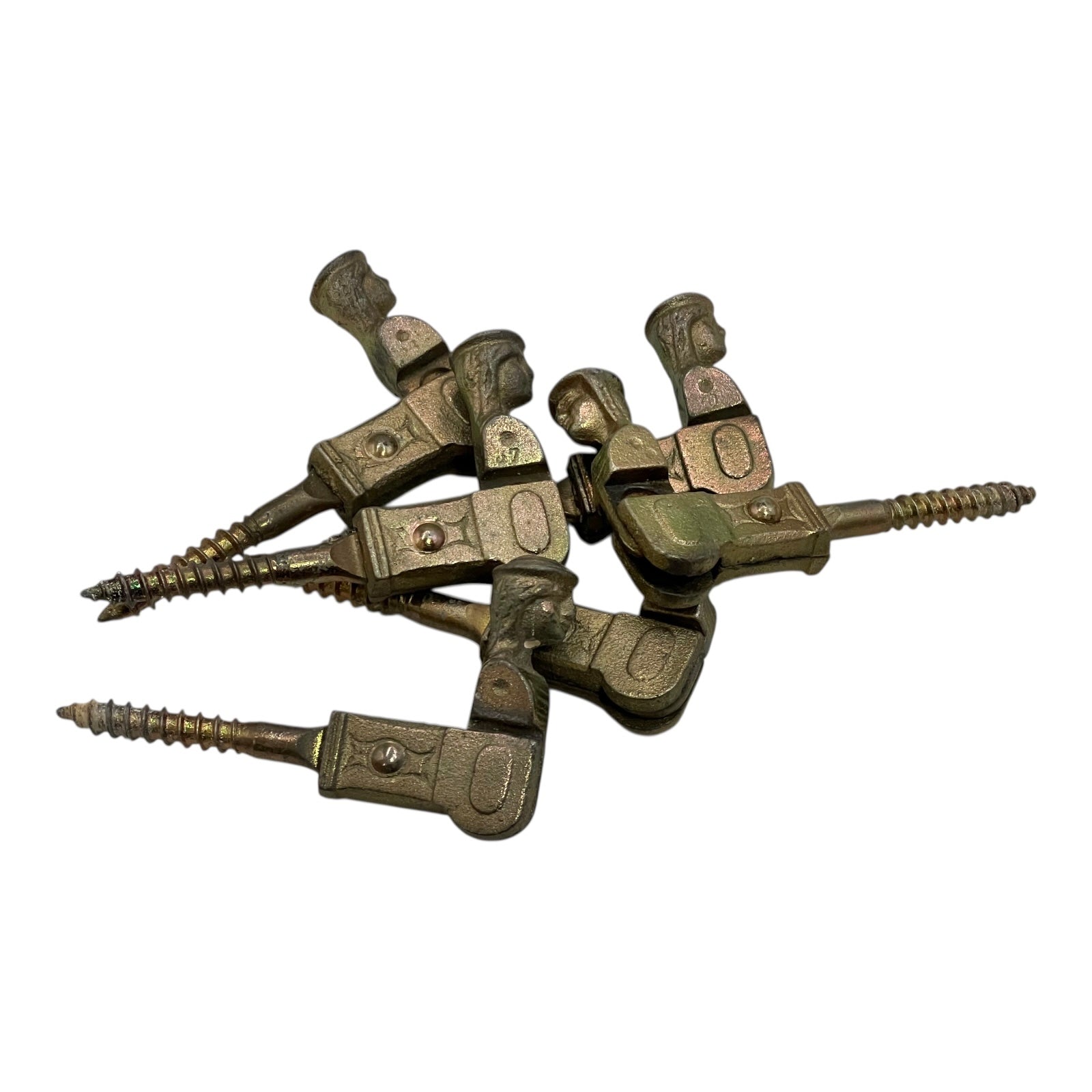 Pile of brass coloured French decorative shutter brackets on a white background