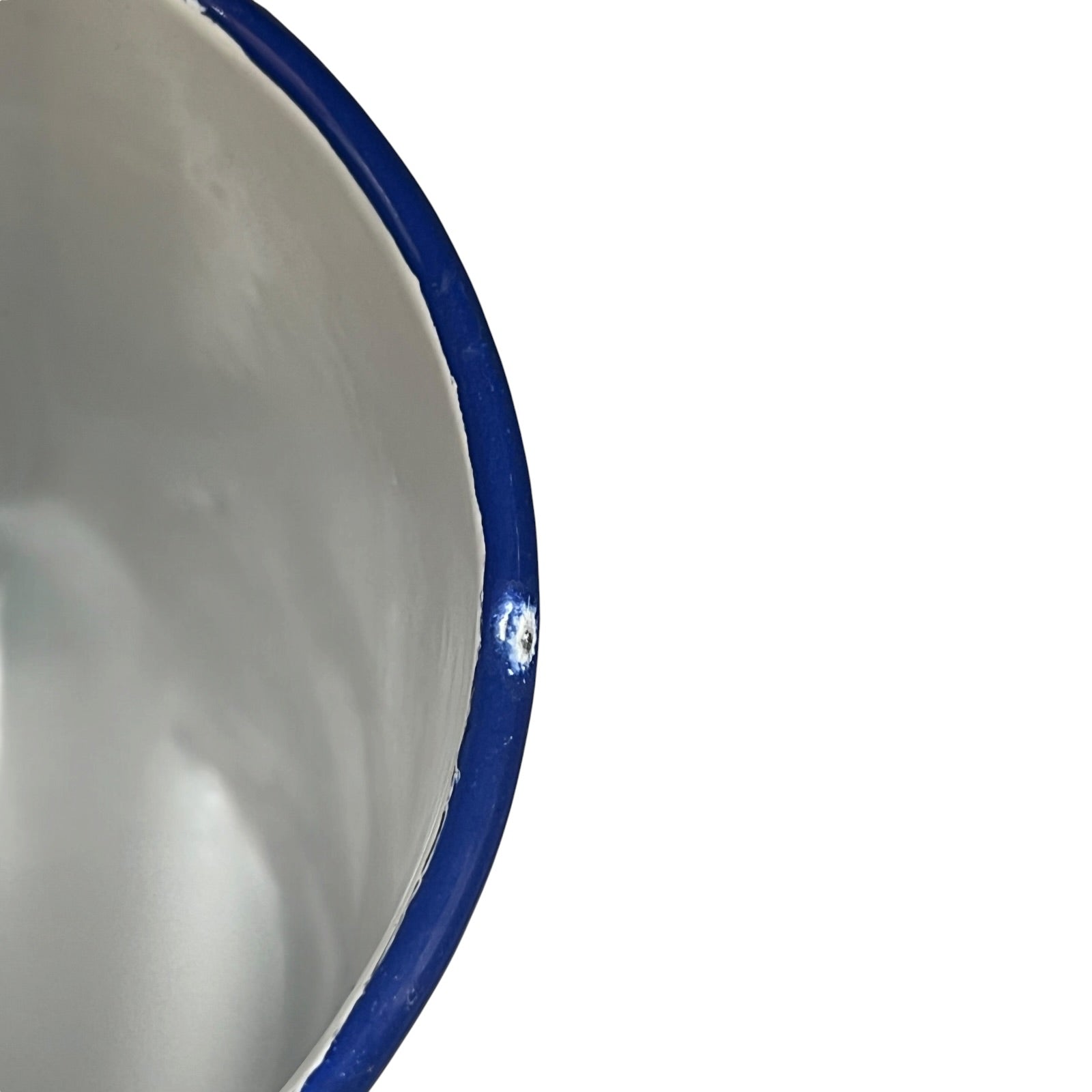 Close-up of the inside of a white enamel planter with a blue rim on a plain white background.