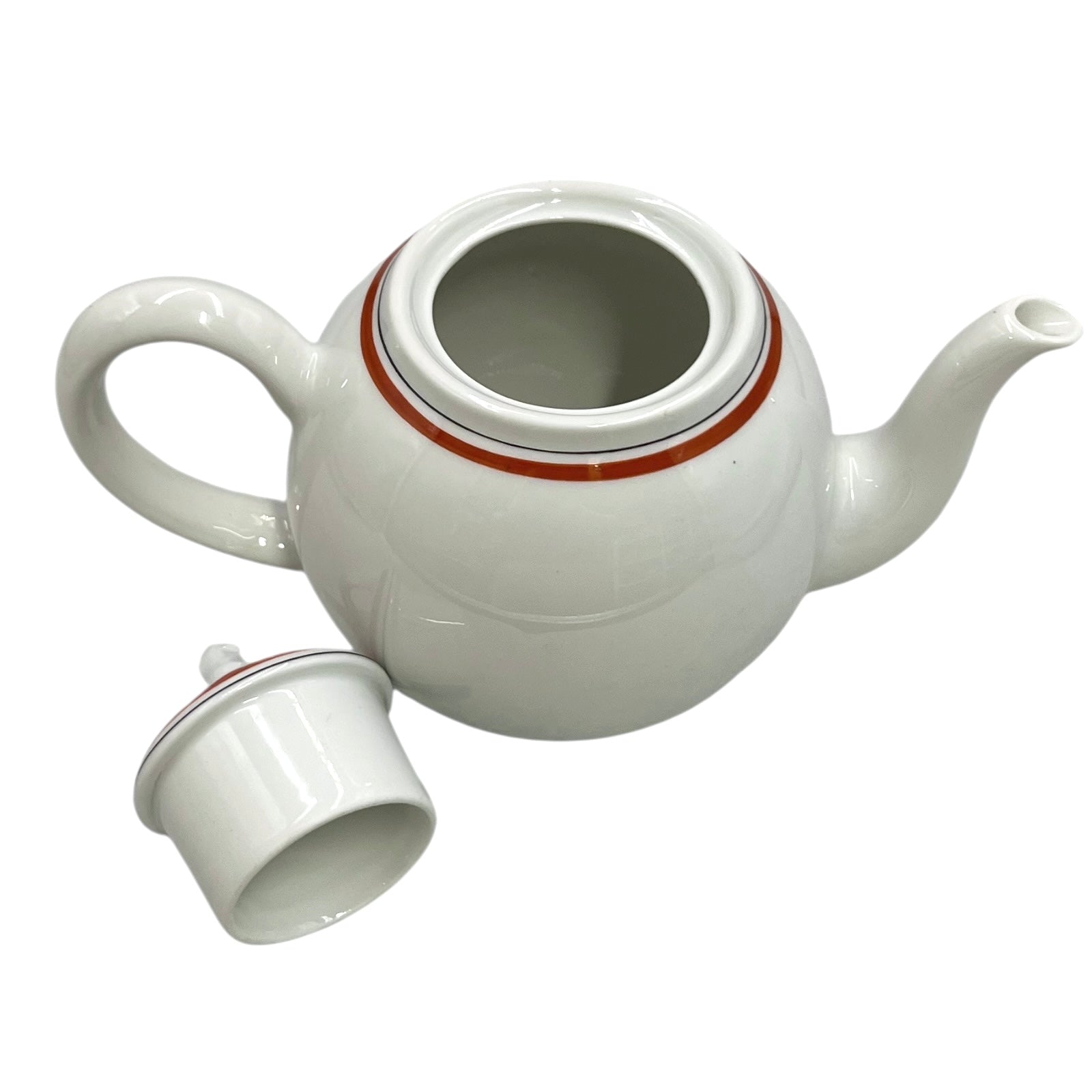 White ceramic teapot with a small white cup on a white background