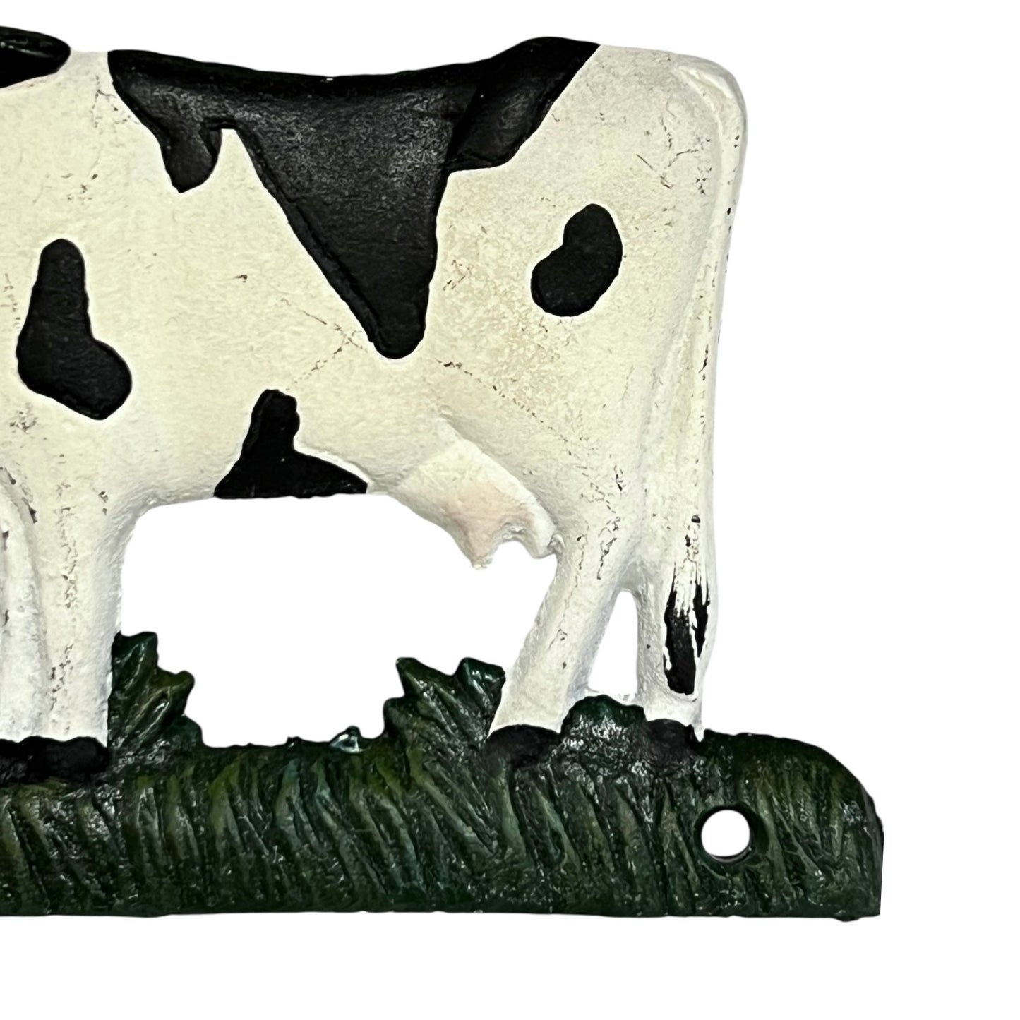 Close up of cow toilet paper holder with black and white pattern on a white background