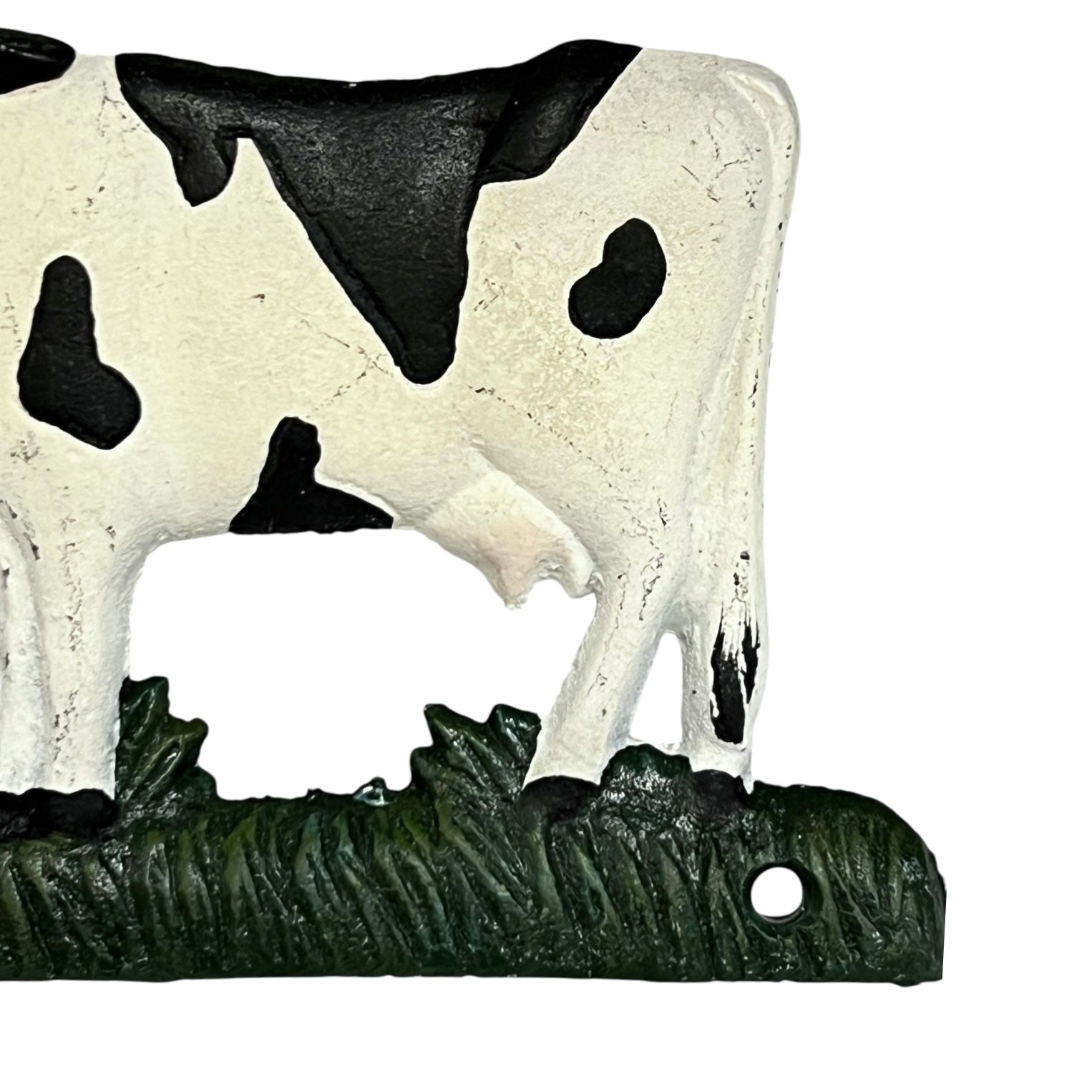 Close up of cow toilet paper holder with black and white pattern on a white background