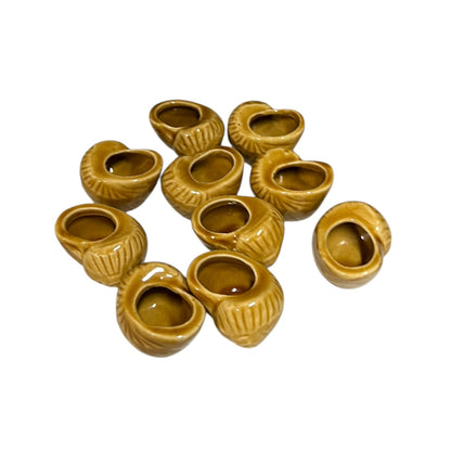 Set of ten small brown ceramic escargots snail pots on a white background