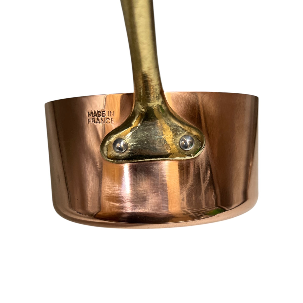 A close-up of a copper saucepan with a brass handle and a polished copper body, featuring the 'MADE IN FRANCE' stamp on the inside, set against a plain white background.