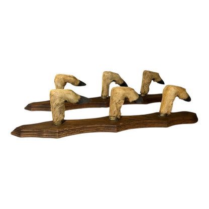 Wooden wall hooks made from taxidermy deer hooves on a white background