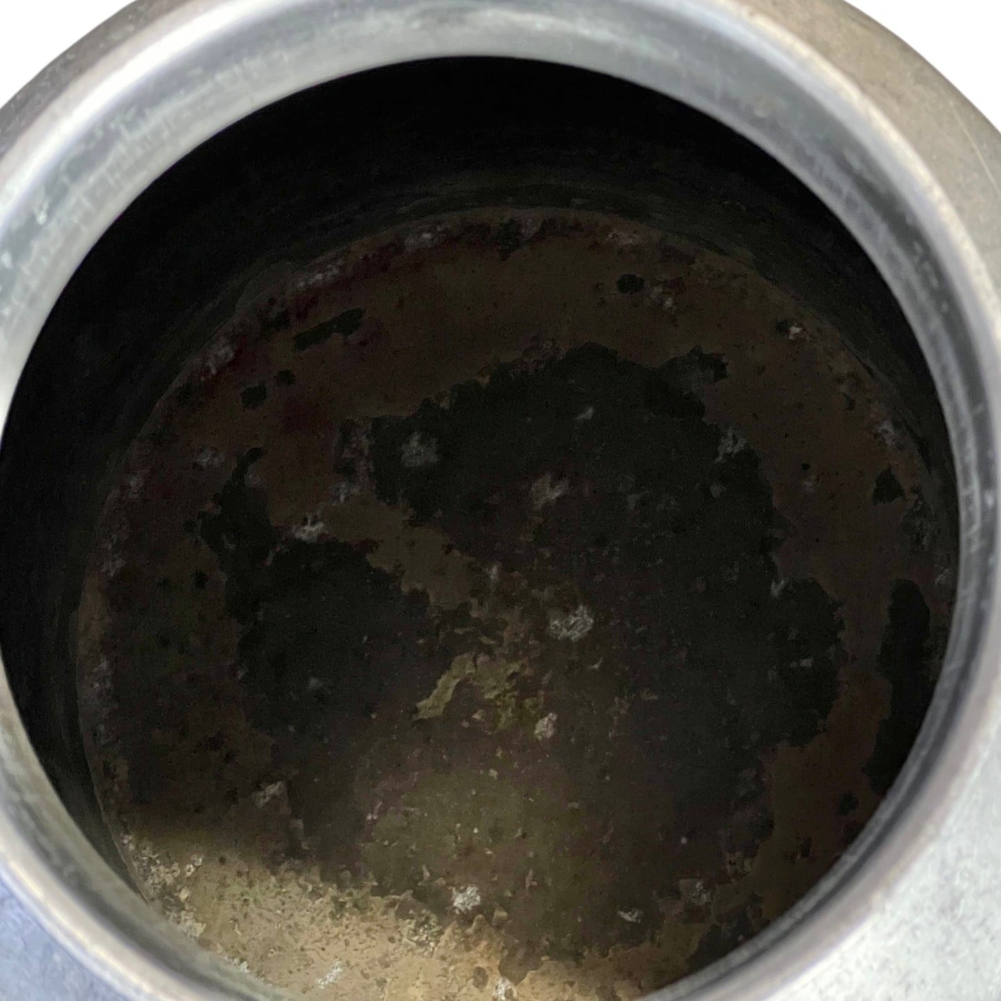 close up of metal milk churn on a white background