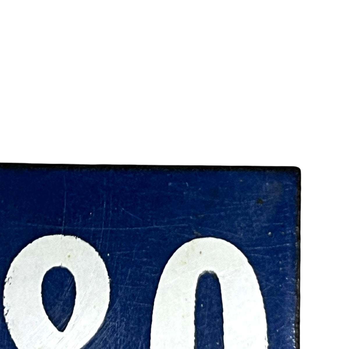 A close-up of a dark blue rectangular sign or plaque with large white painted numerals, cropped against a white background.