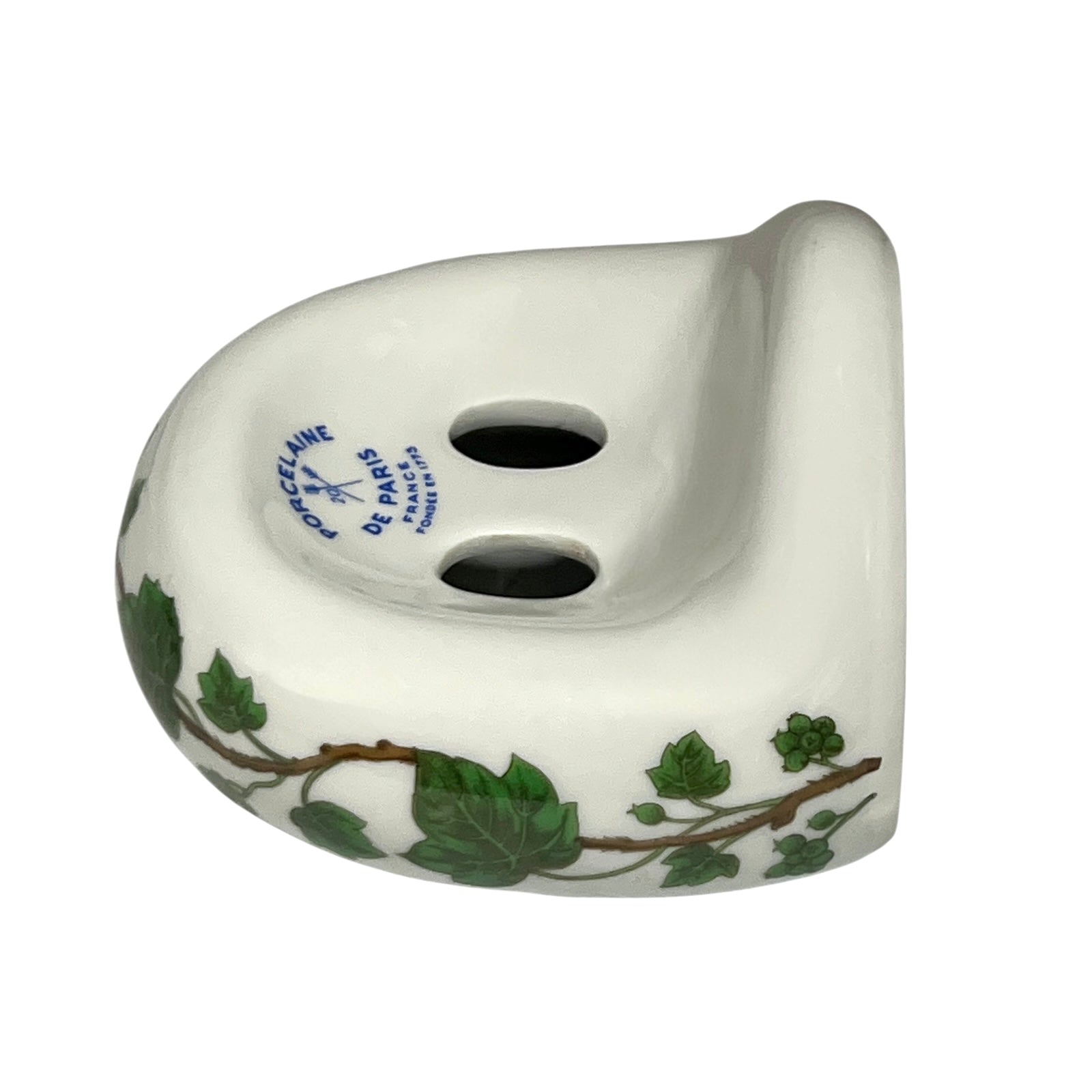 Porcelain bathroom toothbrush holder  featuring green leaf patterns on a white background
