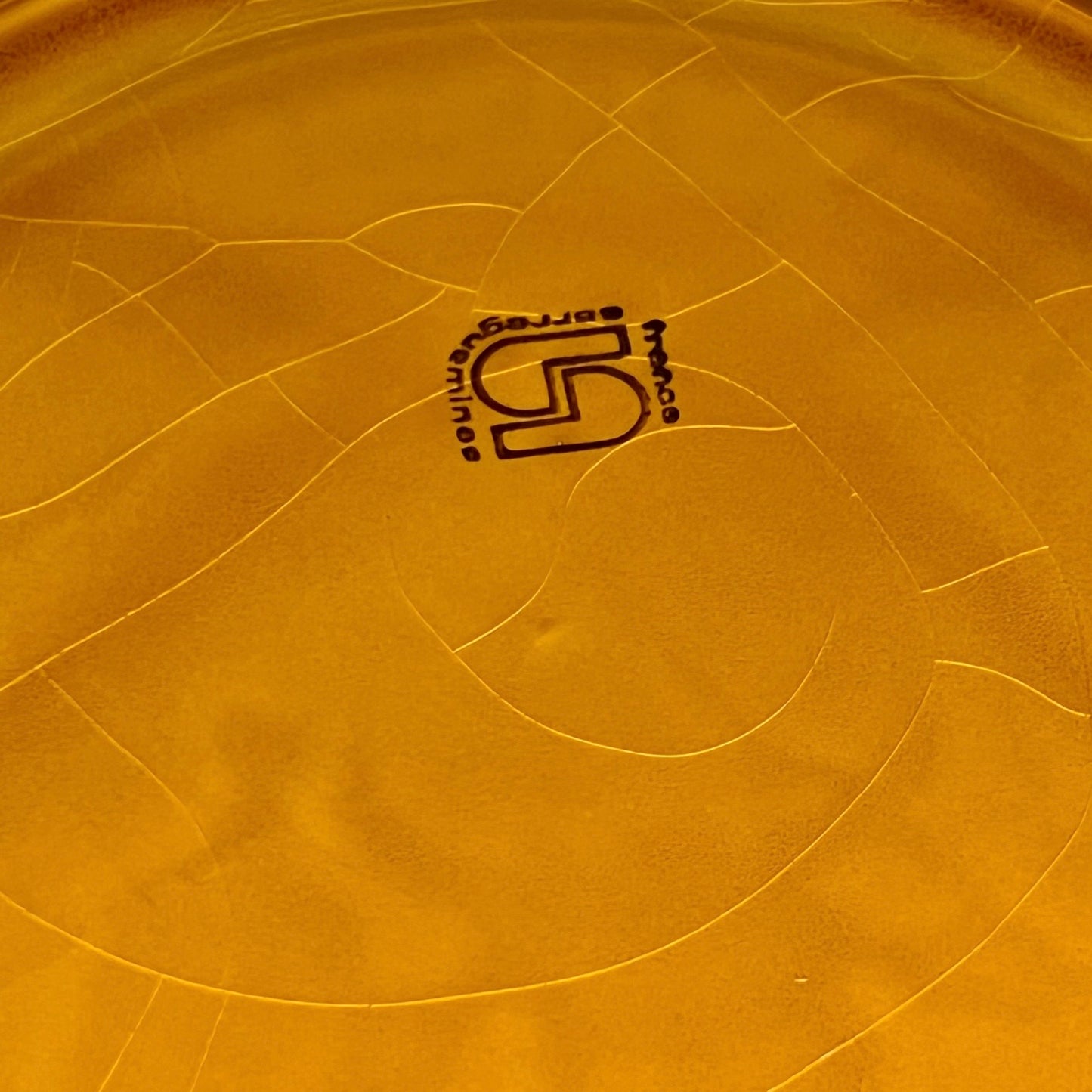Back of fondue plate showing makers stamp on a white background